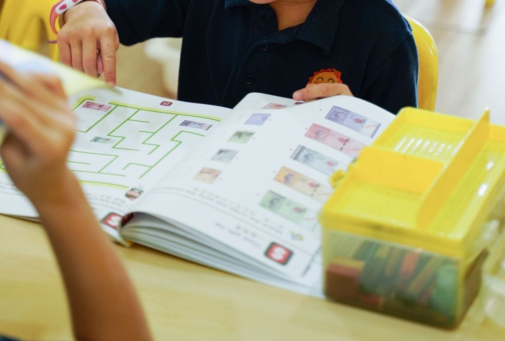 A child working through a maze in an activity book